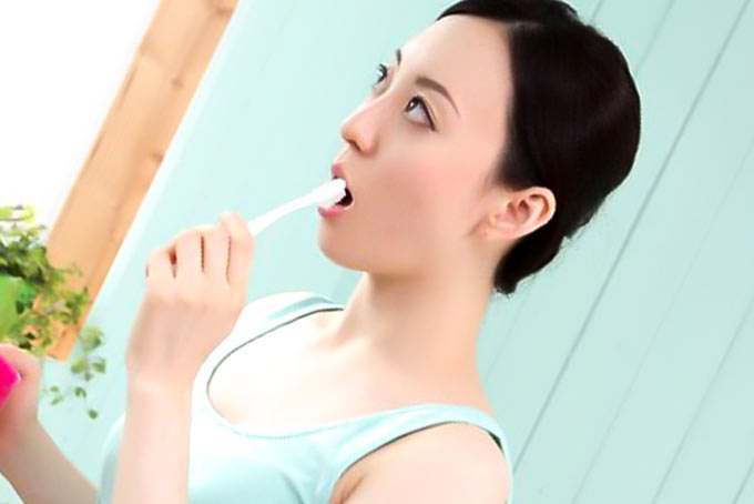 考え事をしながら歯を磨く女性