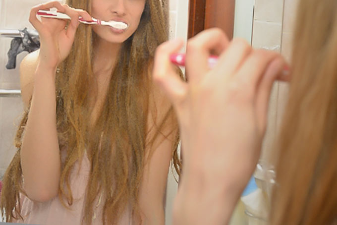 洗面台で歯磨きをする女性